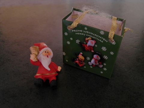 Weihnachtsmann mit Geschenktasche - sitzend mit Glocke