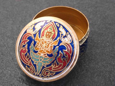 Multifunktionale Dose rund mit einer blauen und roten Figur auf dem Deckel, hergestellt von Juwelier Harnisch, ohne Stein, geöffnet und auf schwarzem Untergrund platziert.