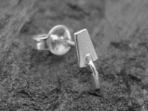 36428-0 Ein einzelner Ohrring in Form einer Maurerkelle aus Sterling Silber, hergestellt von Juwelier Harnisch, auf einem neutralen Untergrund abgebildet.