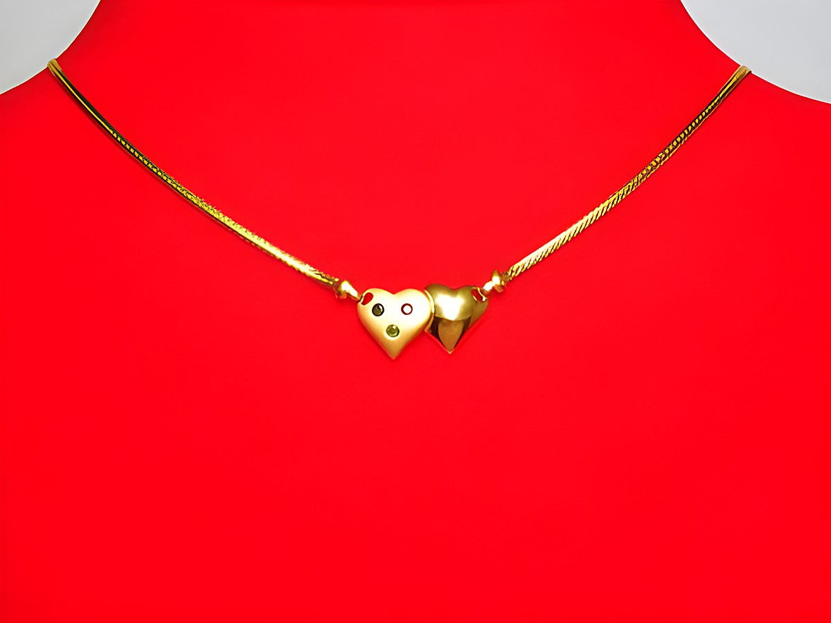 Collier 585 mit zwei Herzen aus Gold, verziert mit Saphir, Rubin und Smaragd. Der Mittelteil hebt sich elegant hervor, an einer 46 cm langen Kette, Hersteller Juwelier Harnisch.