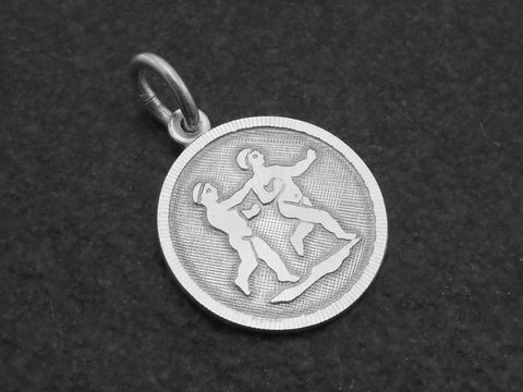 Runder 3D-Silberanhänger mit dem Sternzeichen Zwillinge, gefertigt vom Juwelier Harnisch, zeigt zwei stilisierte Figuren in dynamischer Pose auf strukturiertem Hintergrund.