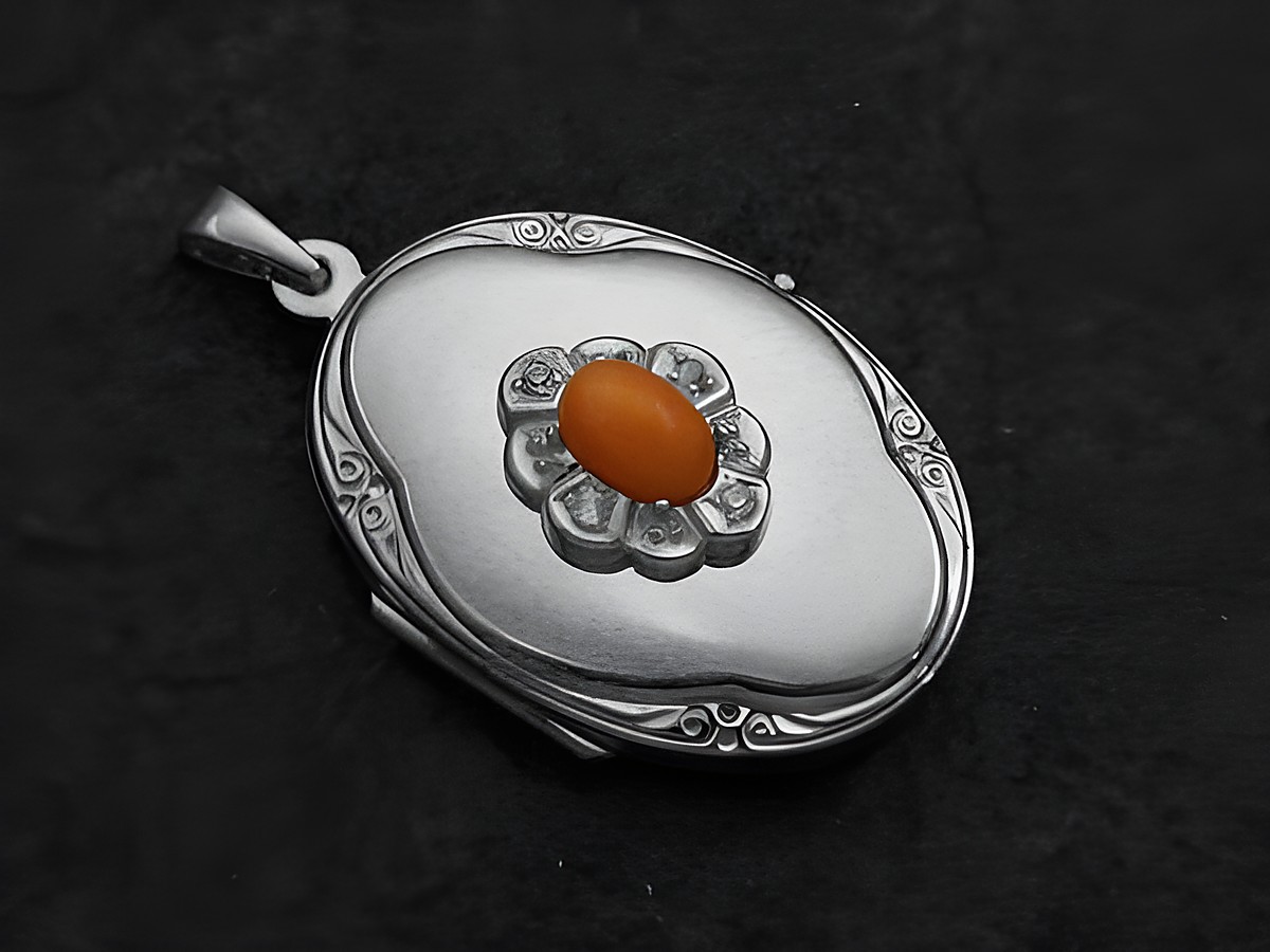 Medaillon aus Weißgold 585 mit einem Cabochon aus koralle in orange, eingefasst in einer Blütenform mit weiteren kleinen Steinen, hergestellt von Juwelier Harnisch.