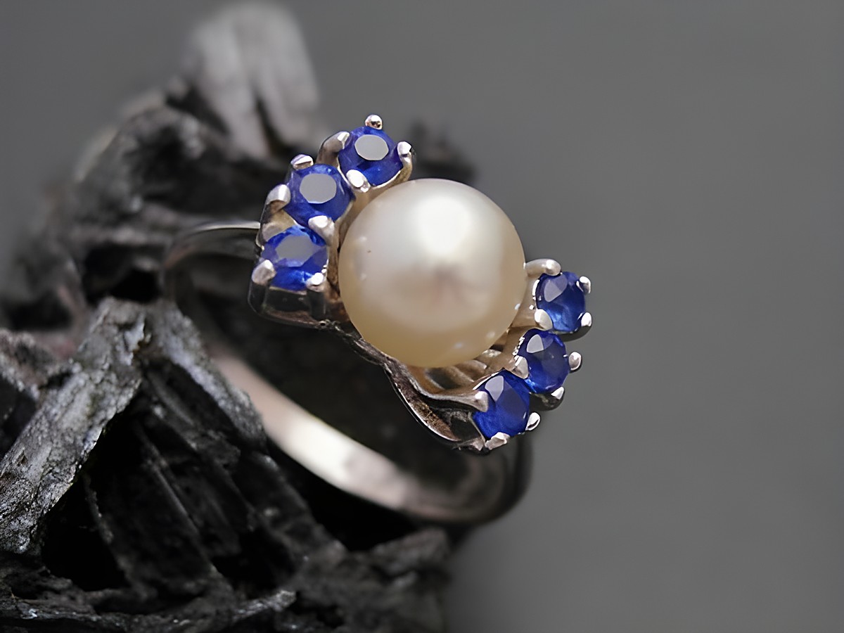Weißgold Perlen Ring edel Gr. 54 6,9 mm Zuchtperle und synthetische Saphire Hersteller Juwelier Harnisch bis Gr. 54 17,5. Elegantes Design mit einer zentralen Perle und blauen Akzenten.