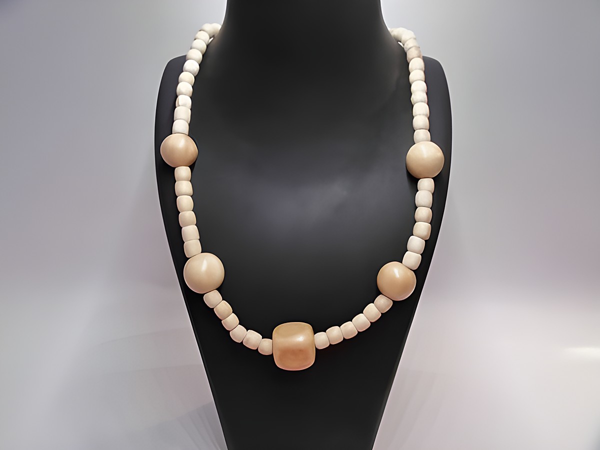 Holzkette - Multiform - 19 mm - naturbraun - 60 cm von Juwelier Harnisch, aus unterschiedlich geformten Holzperlen gefertigt, auf einem schwarzen Präsentationsstand.