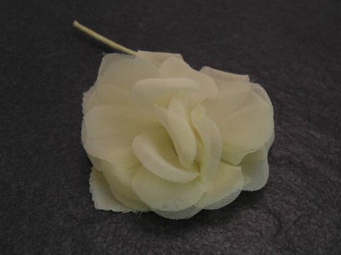 Haarschmuck aus gelber Textilblume von Juwelier Harnisch, ideal für sommerliche Anlässe, verleiht jedem Outfit eine frische Note.