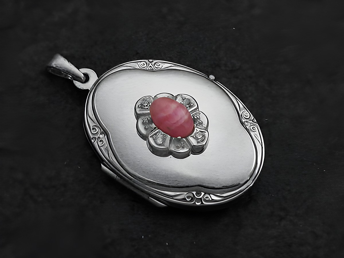 Rhodochrosit Medaillon Cabochon in Weißgold 585, gefertigt von Juwelier Harnisch, oval mit filigranen Details und einem leuchtenden rosa Stein in der Mitte, edel und zeitlos.