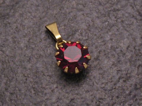 Roter Strass Anhänger in rundem Design mit goldfarbener Halterung, Sexy City Look, Hersteller Juwelier Harnisch, ideal für eine elegante Ergänzung zu verschiedenen Outfits.