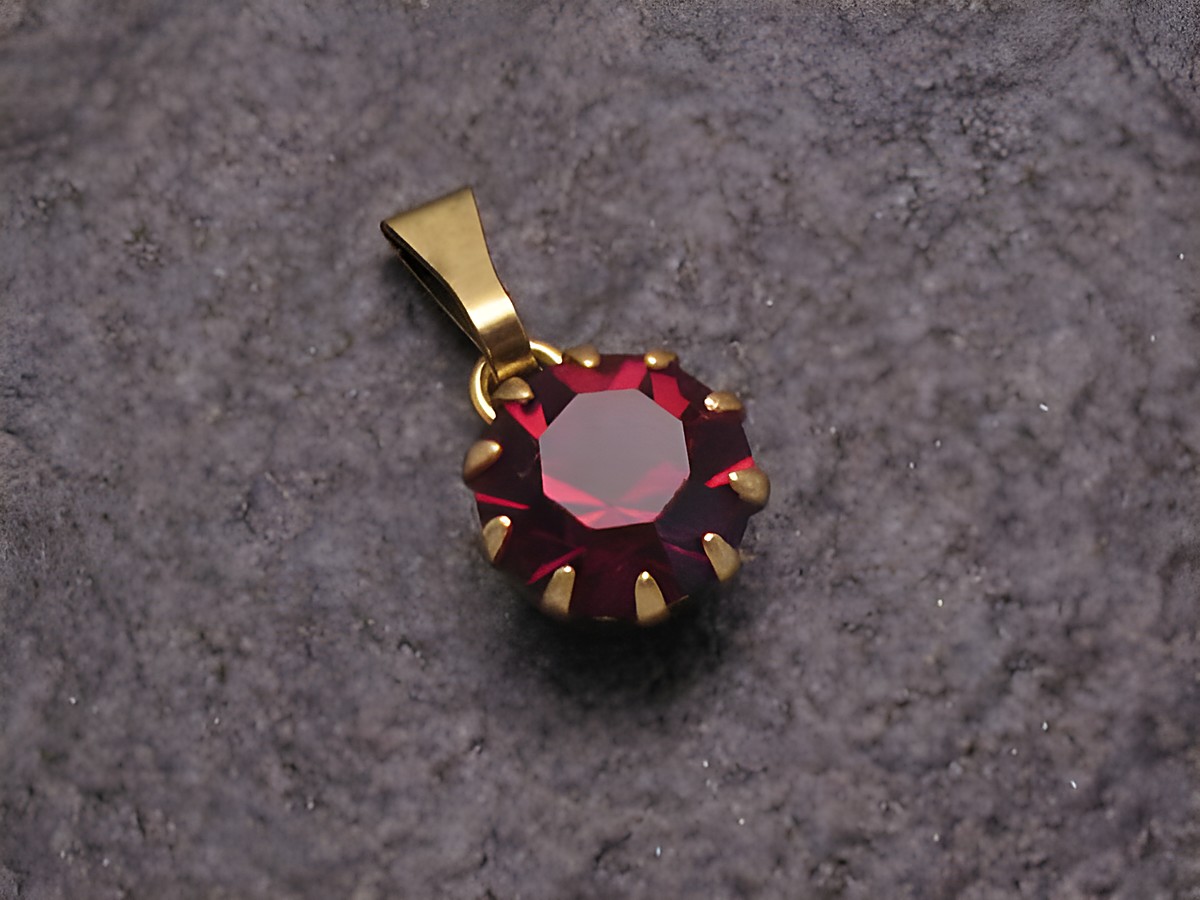 Roter Strass Anhänger in rundem Design mit goldfarbener Halterung, Sexy City Look, Hersteller Juwelier Harnisch, ideal für eine elegante Ergänzung zu verschiedenen Outfits.
