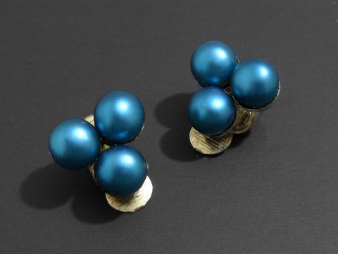 Modeschmuck Ohrclip elegant in grün matt mit Zuchtperlenimitation von Juwelier Harnisch. Die Ohrclips zeigen eine auffällige vierer Anordnung von glänzenden Perlen.