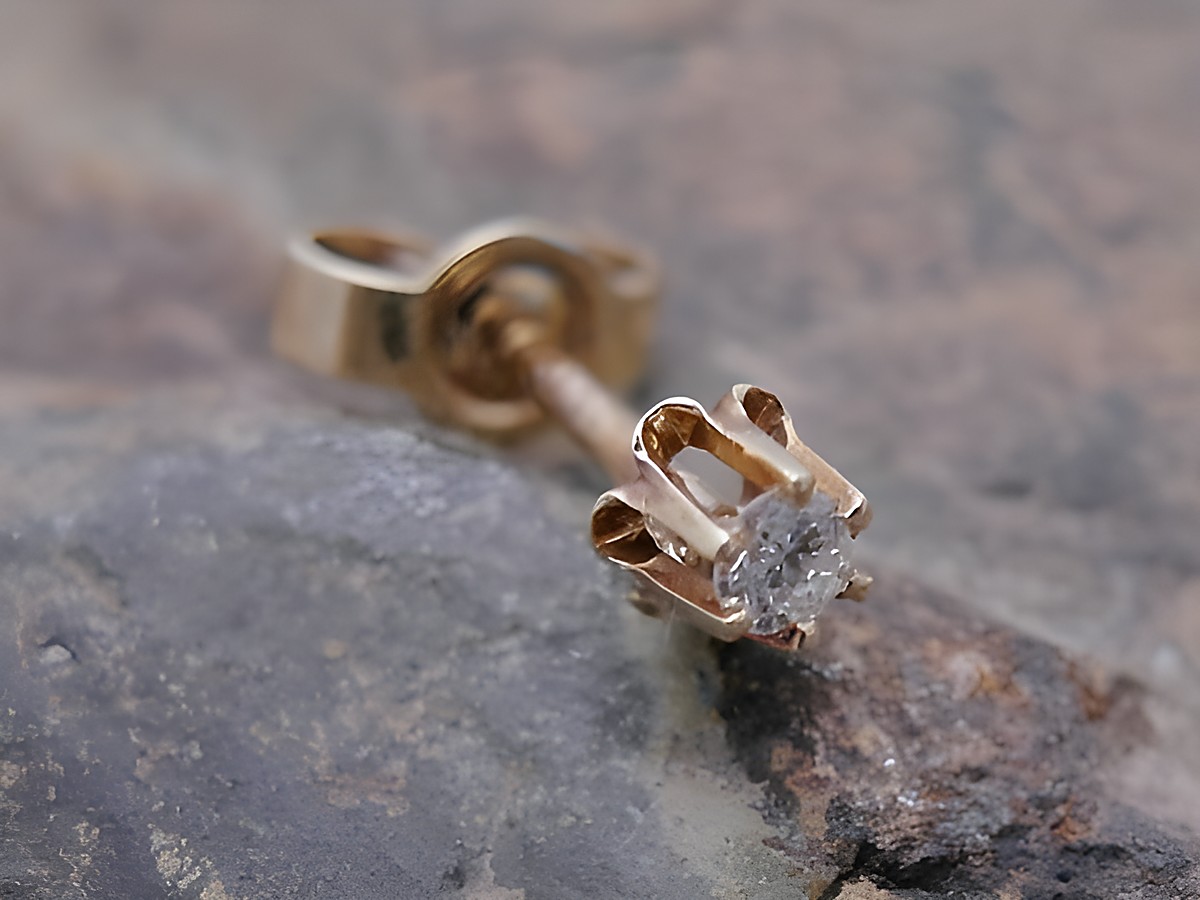Ein einzelner unisex Ohrstecker aus Gold 585 im vintage Look, besetzt mit einem Brillant, gefertigt von Juwelier Harnisch. Der Ohrstecker hat eine filigrane Krappenfassung.