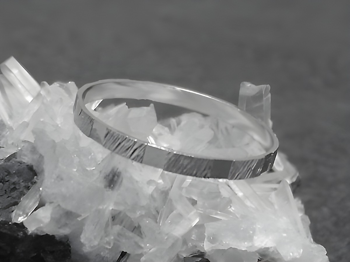 Silber Ring rhodiniert 2mm breit Größe 60 19mm auf Kristallen präsentiert, von Juwelier Harnisch bis Größe 60 19,1. Élegant mit strukturierter Oberfläche.