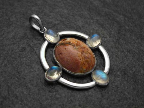 Anhänger Design aus Sterling Silber mit einem feurigen Feueropal in der Mitte, umgeben von schimmerndem Mondstein, gefertigt von Juwelier Harnisch, ansprechendes Schmuckstück.