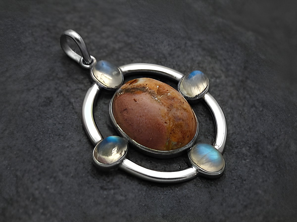 Anhänger Design aus Sterling Silber mit einem feurigen Feueropal in der Mitte, umgeben von schimmerndem Mondstein, gefertigt von Juwelier Harnisch, ansprechendes Schmuckstück.