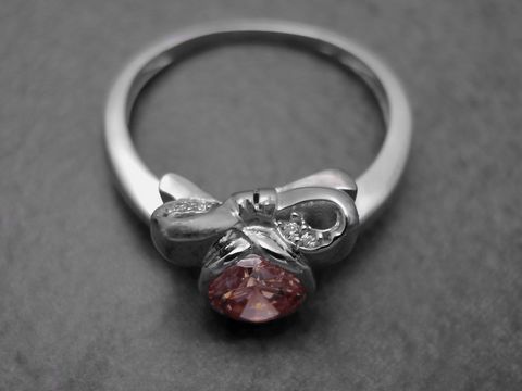 Ring aus Sterling Silber in Größe 52 mit rhodinierten Oberflächen, verziert mit Zirkonia und einem auffälligen rosa Stein, hergestellt von Juwelier Harnisch.