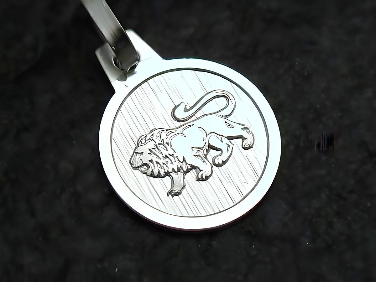 Löwe Sterling Silber Sternzeichen Anhänger mit detailreicher Darstellung eines Löwen auf strukturiertem Hintergrund, Hersteller Juwelier Harnisch.