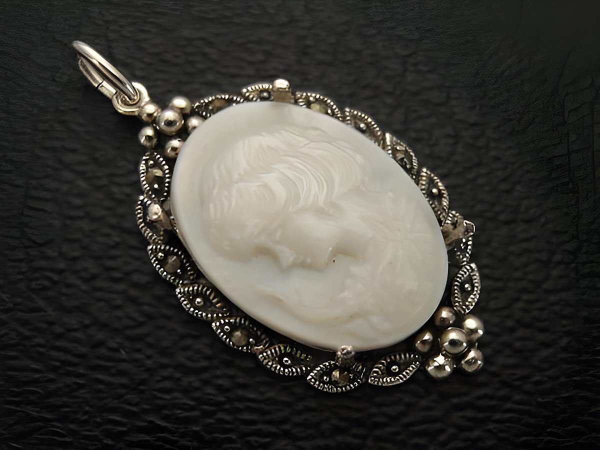 Cabochon - Perlmutt - Silber Medaillon Anhänger von Juwelier Harnisch mit einer filigranen Umrandung, der Cabochonstein zeigt ein zartes, detailreiches Relief einer weiblichen Figur.