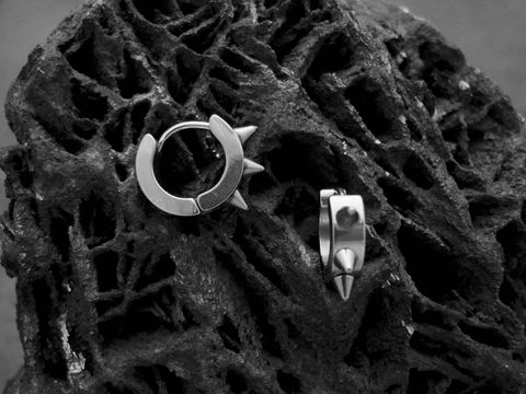 Edelstahl Creolen mit SPIKES von Juwelier Harnisch, modern und trendy, perfekt für einen stylishen Look, auf einem schwarzen, strukturierten Hintergrund.