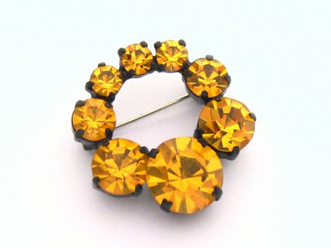 Strass Brosche rund in orange, gefasst, neu, Hersteller Juwelier Harnisch, umgeben von gelb-braunen Strasssteinen, verleiht eleganten Glanz und ist ideal für besondere Anlässe.