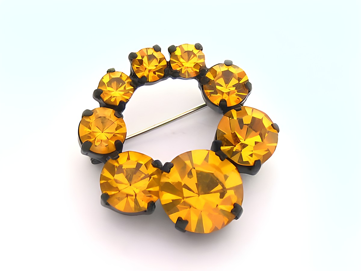 Strass Brosche rund in orange, gefasst, neu, Hersteller Juwelier Harnisch, umgeben von gelb-braunen Strasssteinen, verleiht eleganten Glanz und ist ideal für besondere Anlässe.