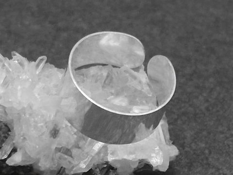 Silber Ring 8 mm breit und poliert in der Größe 55 bis 65, Hersteller Juwelier Harnisch, ohne Stein, auf Kristallbasis präsentiert.