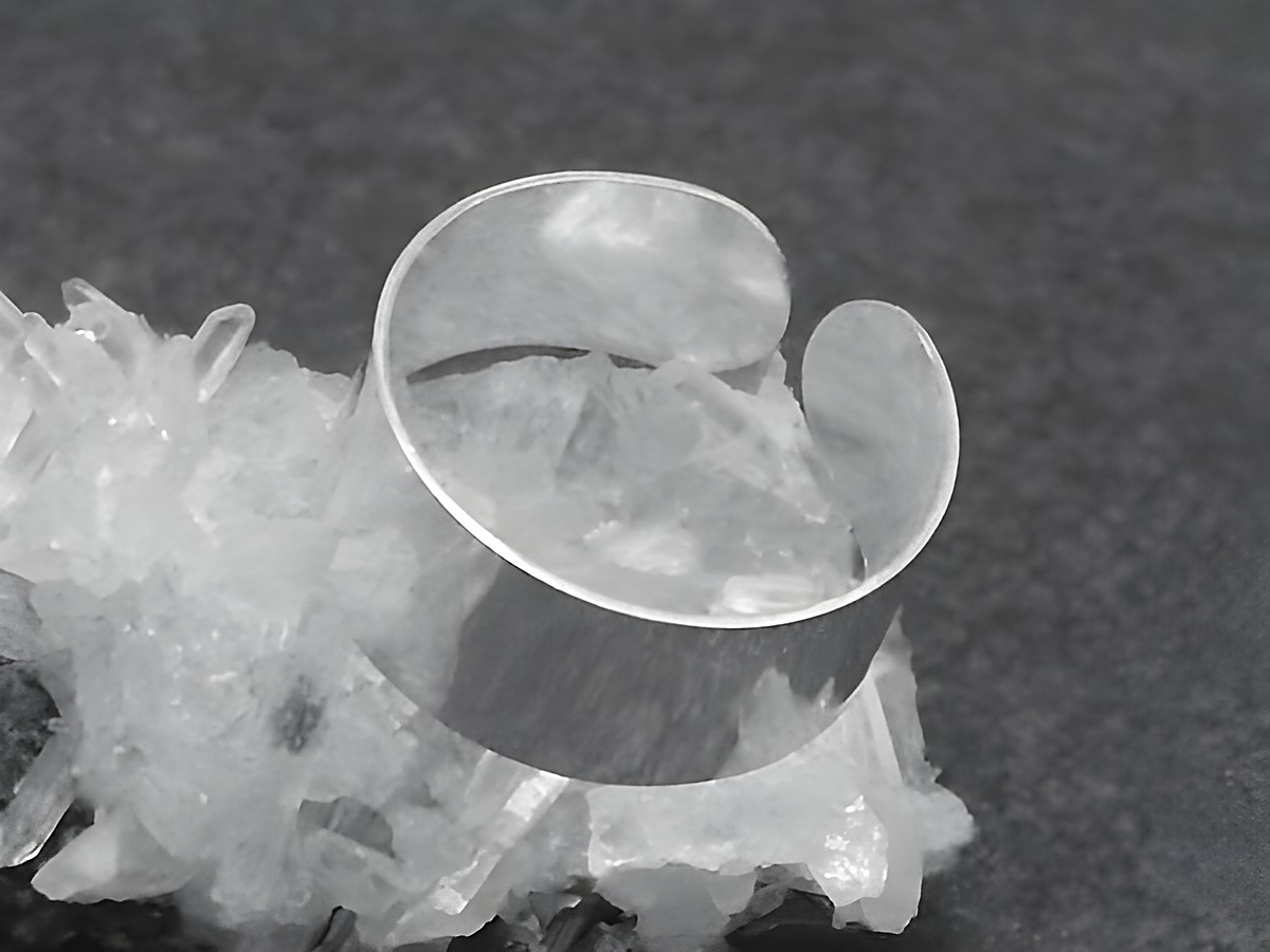 Silber Ring 8 mm breit und poliert in der Größe 55 bis 65, Hersteller Juwelier Harnisch, ohne Stein, auf Kristallbasis präsentiert.