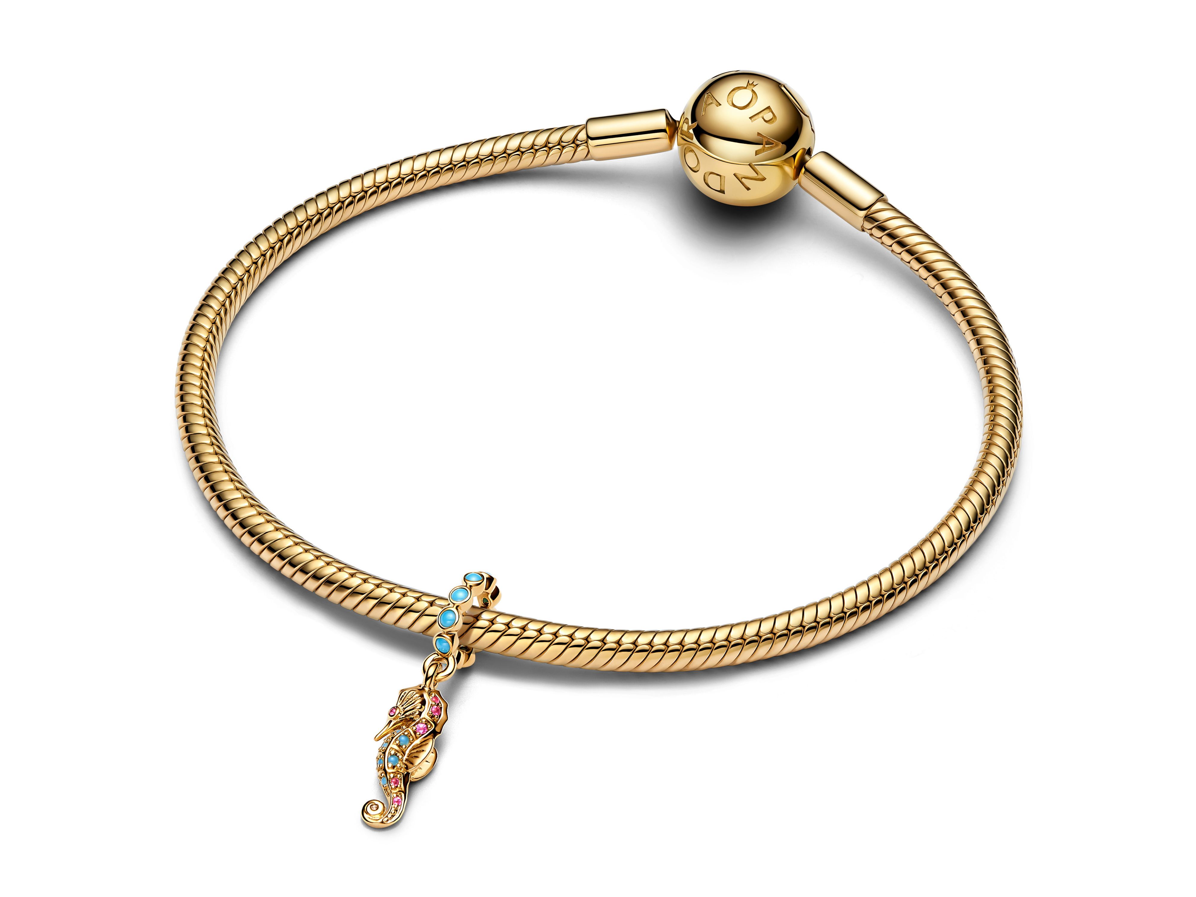 Ein eleganter Pandora Charm in Form eines Seepferdchens aus gelbgold vergoldetem Material, verziert mit bunten Steinen, hängt an einem geflochtenen Armband.