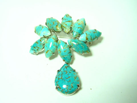 60357-0 Wunderschöne Brosche in Türkis mit gefassten Steinen, neu vom Hersteller Juwelier Harnisch. Die Brosche hat einen auffälligen Türkis-Look und verleiht jedem Outfit einen besonderen Akzent.