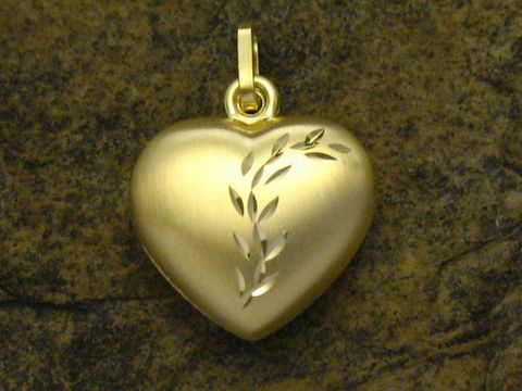 Herzanhänger aus Gold mit plastischer Ranke, Durchmesser 15 mm, Hersteller Juwelier Harnisch, an einem steinfarbenen Hintergrund platziert.