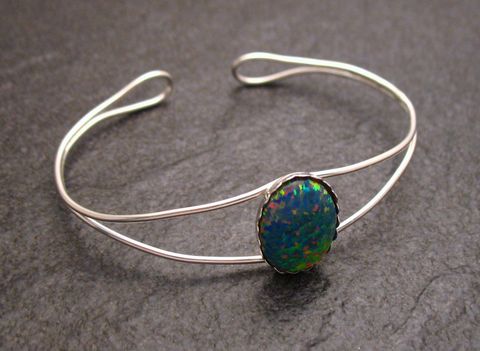 Bunter grober Armreifen aus Sterling Silber mit einem ovalen Opal, Umfang 18 cm, hergestellt von Juwelier Harnisch. Der Schmuck glänzt durch seine lebendigen Farben.