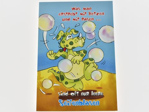 Lustige Geburtstagskarte mit einem Comic-Dino, der fröhlich mit bunten Seifenblasen spielt. Schriftzug mit humorvollem Spruch über leere Seifenblasen. Hersteller Juwelier Harnisch.