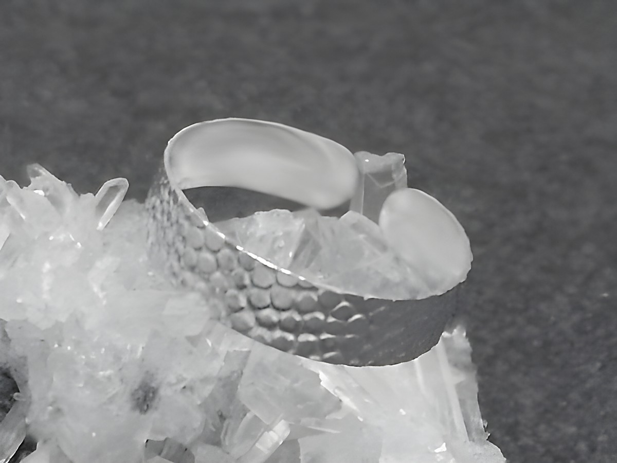 Silber Ring 5 mm breit mit Muster Gr. 55 - 65, Hersteller Juwelier Harnisch, ohne Stein, auf einer Kristallbasis präsentiert.
