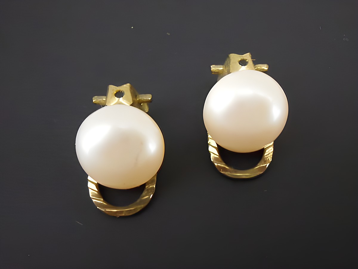 Ohrclip in hellrosa mit zeitlosem Design aus goldfarbenem Material und synth. Zuchtperle, hergestellt von Juwelier Harnisch, ideal für elegante Anlässe.