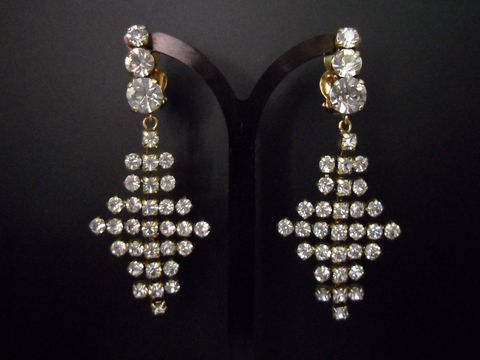 Glamouröse goldfarbene Strass Ohrclips von Juwelier Harnisch mit funkelnden weißen Strasssteinen, die in einem eleganten Design angeordnet sind. Ideal für festliche Anlässe.