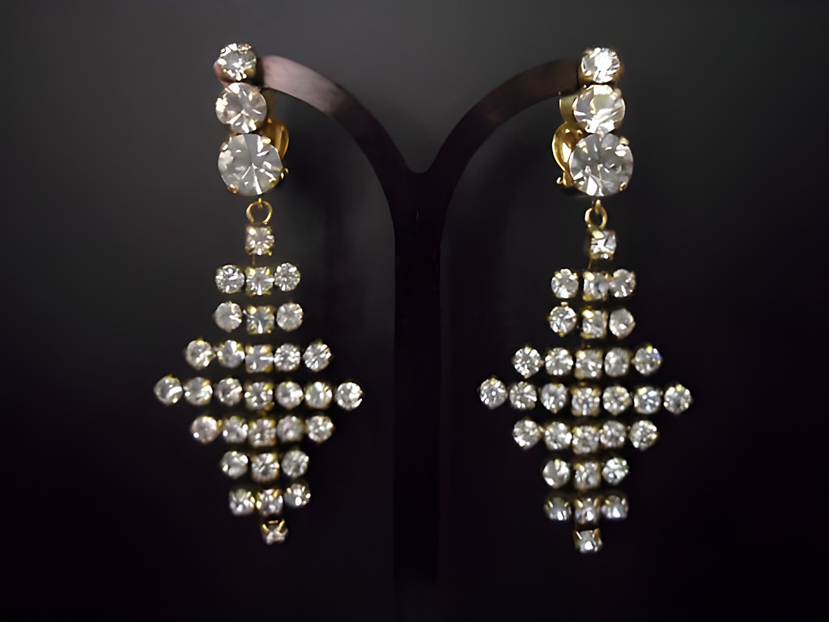 Glamouröse goldfarbene Strass Ohrclips von Juwelier Harnisch mit funkelnden weißen Strasssteinen, die in einem eleganten Design angeordnet sind. Ideal für festliche Anlässe.