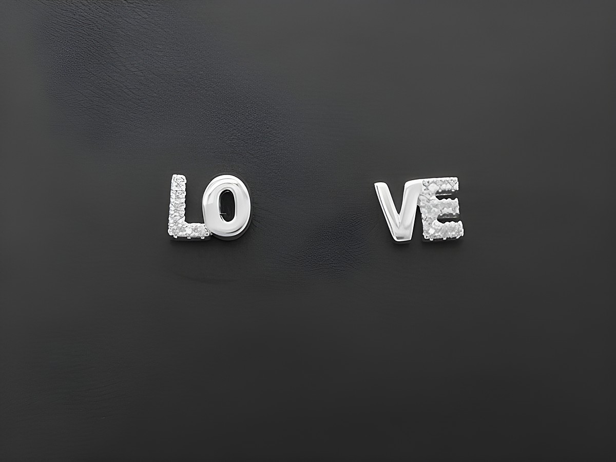 Silber Ohrringe mit LOVE Schriftzug, verziert mit weißen Zirkonia, hergestellt von Juwelier Harnisch. Schlichte und edle Ohrschmuckelemente für jeden Anlass.