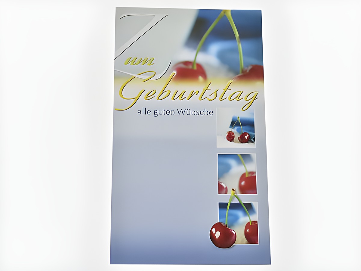 Eine Geburtstagskarte mit Kirschenmotiven, auf der steht "Zum Geburtstag" und "alle guten Wünsche". Die Farben sind überwiegend blau und rot, was eine fröhliche Stimmung vermittelt. Hersteller: Juwelier Harnisch.