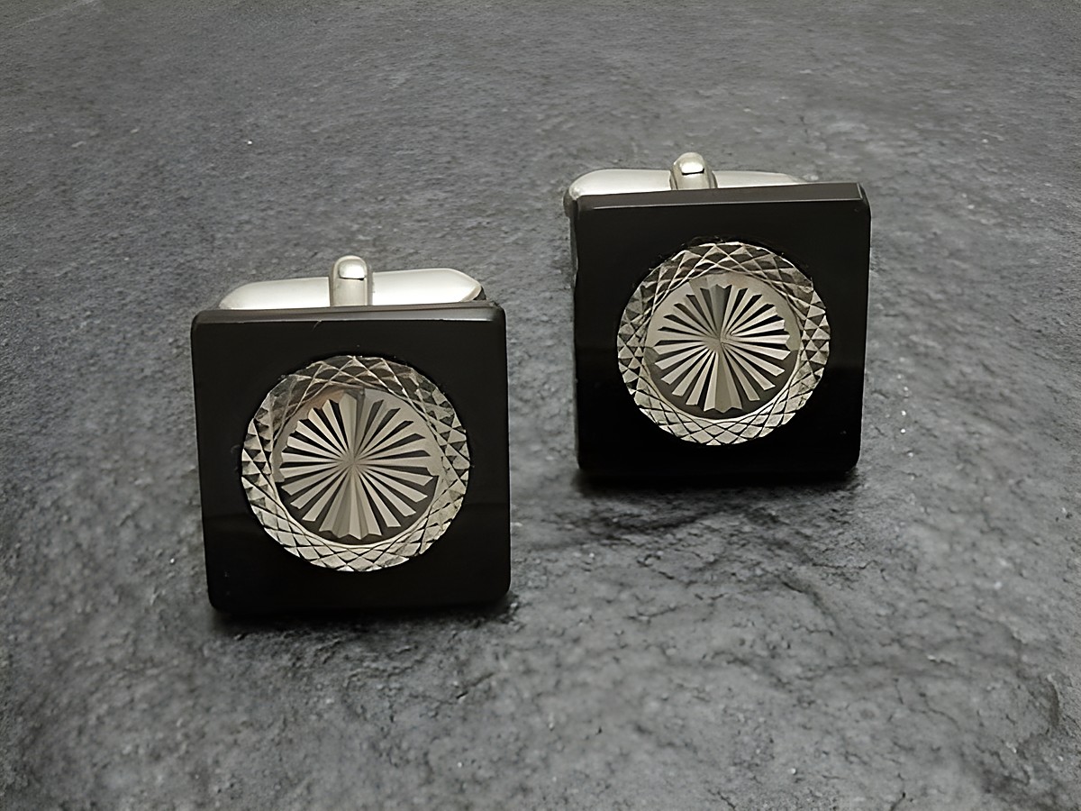 Manschettenknöpfe in silberfarben mit Onyx-Look schwarz von Juwelier Harnisch, dekorativ geprägt und elegant, ideal für formelle Anlässe und Stilbewusstsein.