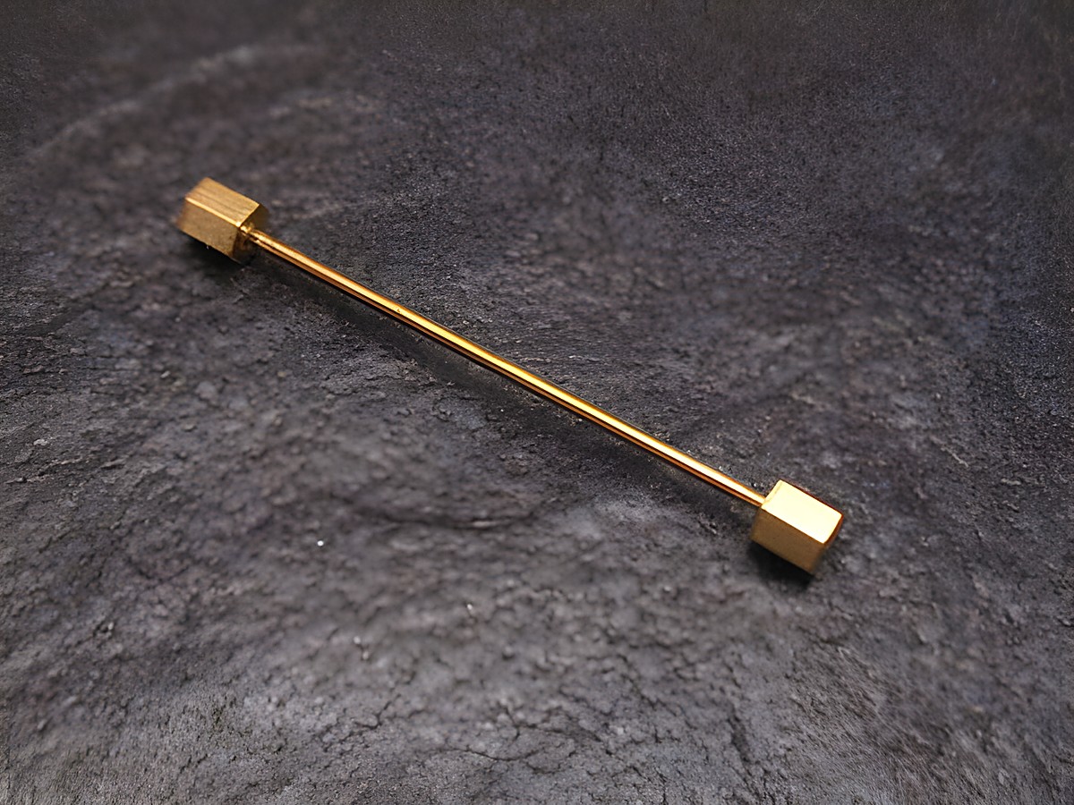Vergoldetes Kragenstäbchen in sechseckiger Form, ideal für die Befestigung von Kragen, hergestellt von Juwelier Harnisch. Perfekte Ergänzung für stilvolle Kleidung.