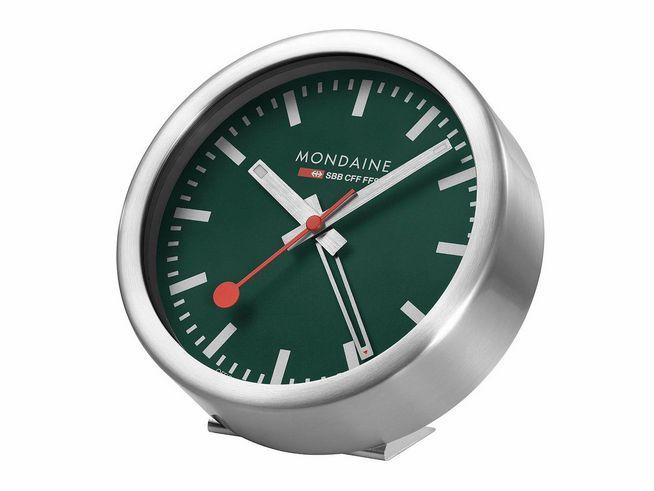 Der Mondaine A997.MCAL.66SBV.1 Wecker mit mattiertem Aluminiumgehäuse hat ein schlichtes, modernes Design in Waldgrün und eine gut ablesbare Ziffernblattgestaltung mit roten Akzenten.