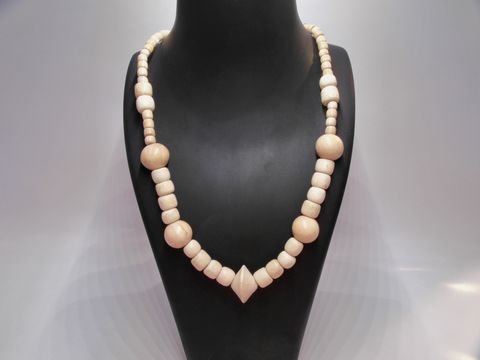 Holzkette aus naturbraunem Holz mit verschiedenen Formen und Größen, 22 mm dick und 60 cm lang, präsentiert auf einem stilvollen Schmuckständer, Hersteller Juwelier Harnisch.