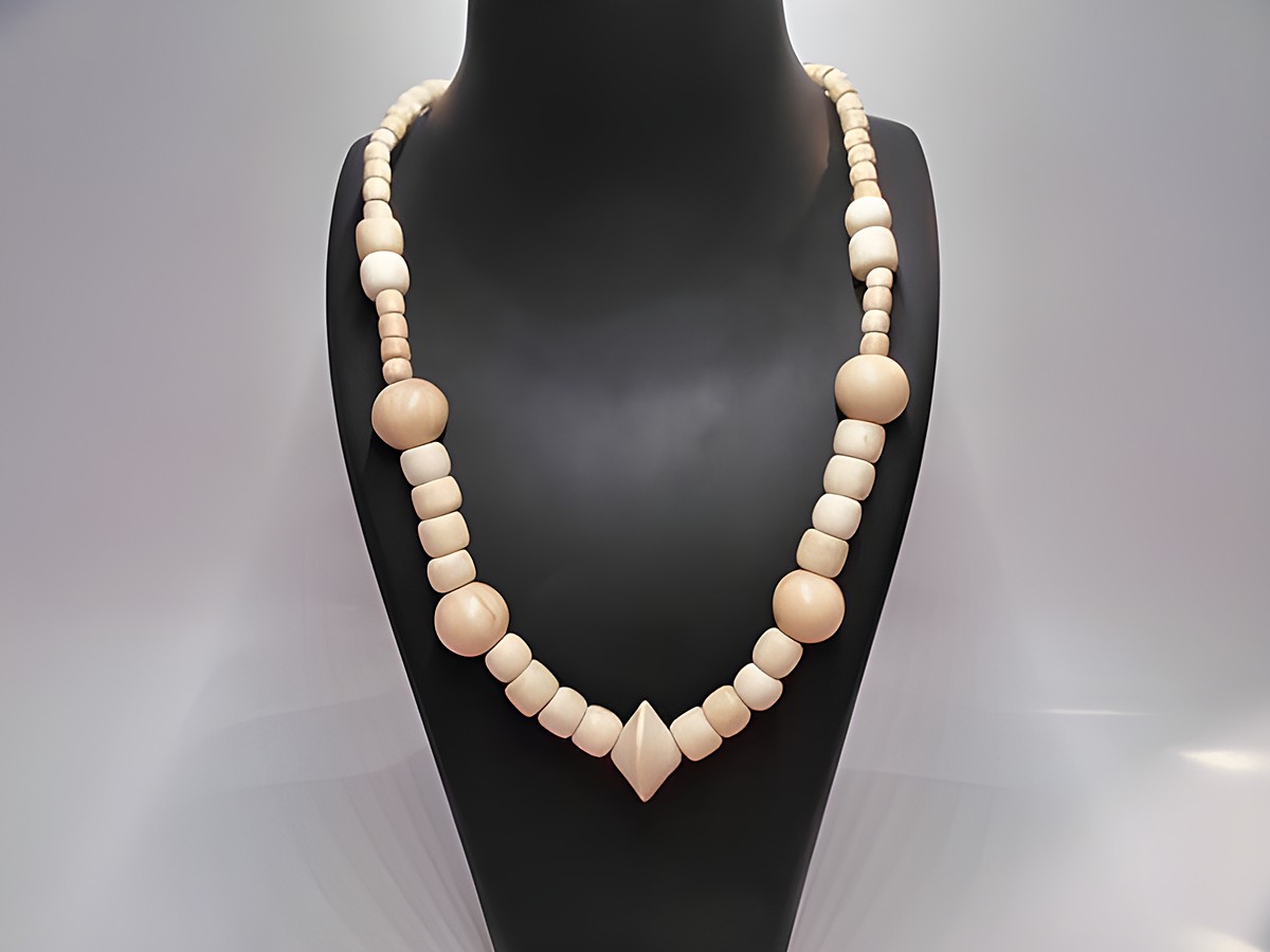 Holzkette aus naturbraunem Holz mit verschiedenen Formen und Größen, 22 mm dick und 60 cm lang, präsentiert auf einem stilvollen Schmuckständer, Hersteller Juwelier Harnisch.
