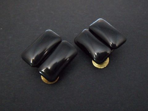 Schwarze Ohrclips aus Kunstharz mit zeitloser Form und goldfarbenen Details, hergestellt vom Juwelier Harnisch, ideal für stilvolle Akzente in jedem Outfit.