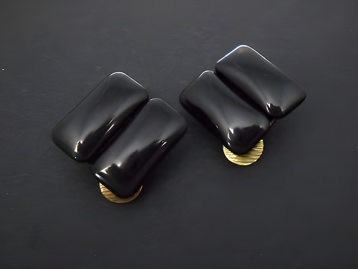 Schwarze Ohrclips aus Kunstharz mit zeitloser Form und goldfarbenen Details, hergestellt vom Juwelier Harnisch, ideal für stilvolle Akzente in jedem Outfit.