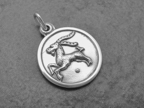 Silber Anhänger mit rundem Design, Sternzeichen Steinbock abgebildet, Hersteller Juwelier Harnisch, detaillierte Darstellung des Steinbocks in der Mitte des Anhängers.