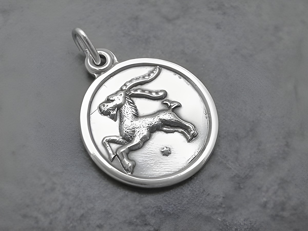 Silber Anhänger mit rundem Design, Sternzeichen Steinbock abgebildet, Hersteller Juwelier Harnisch, detaillierte Darstellung des Steinbocks in der Mitte des Anhängers.