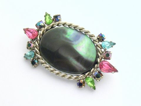 Brosche in bunt mit gefassten Strass Steinen, Hersteller Juwelier Harnisch, verfügt über einen ovalen Kern und leuchtende Steine in Pink, Grün, Blau und weiteren Farben.