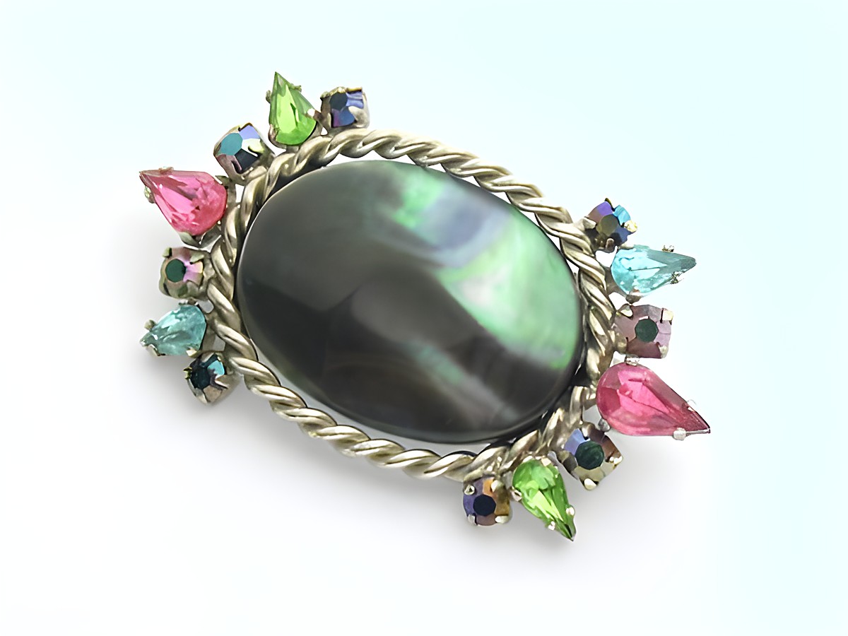 Brosche in bunt mit gefassten Strass Steinen, Hersteller Juwelier Harnisch, verfügt über einen ovalen Kern und leuchtende Steine in Pink, Grün, Blau und weiteren Farben.