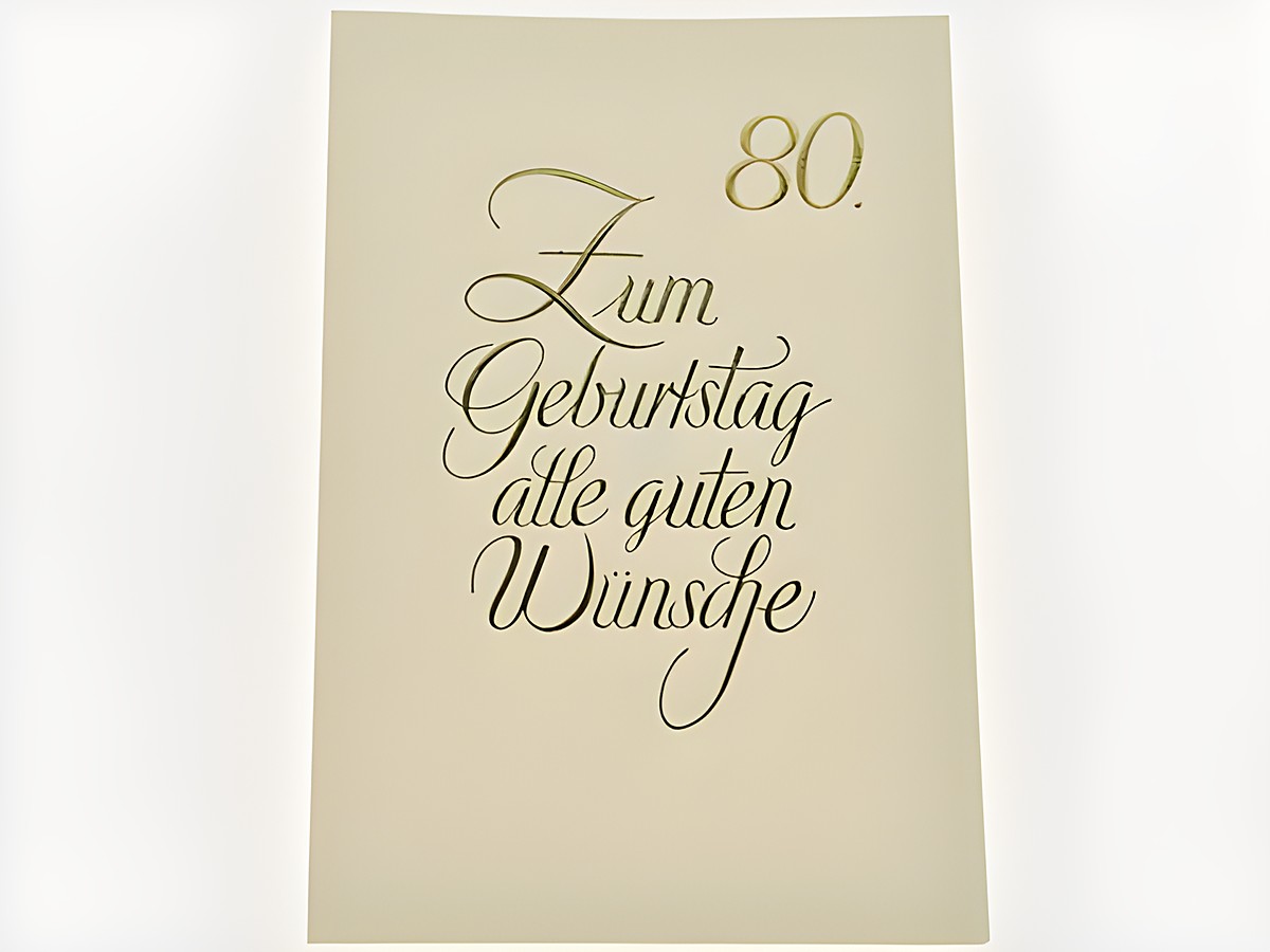 Geburtstagskarte in schlichten Design mit goldener Schrift, elegant gestaltet, mit der Aufschrift Zum Geburtstag alle guten Wünsche sowie der Zahl 80, Hersteller Juwelier Harnisch.