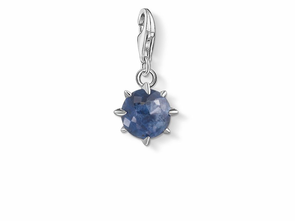 Thomas Sabo Charm-Anhänger in Silber mit blauen Monatsstein für September, facettierter Stein, durch Spikes umgeben, attraktives Design für personalisierte Schmuckstücke.