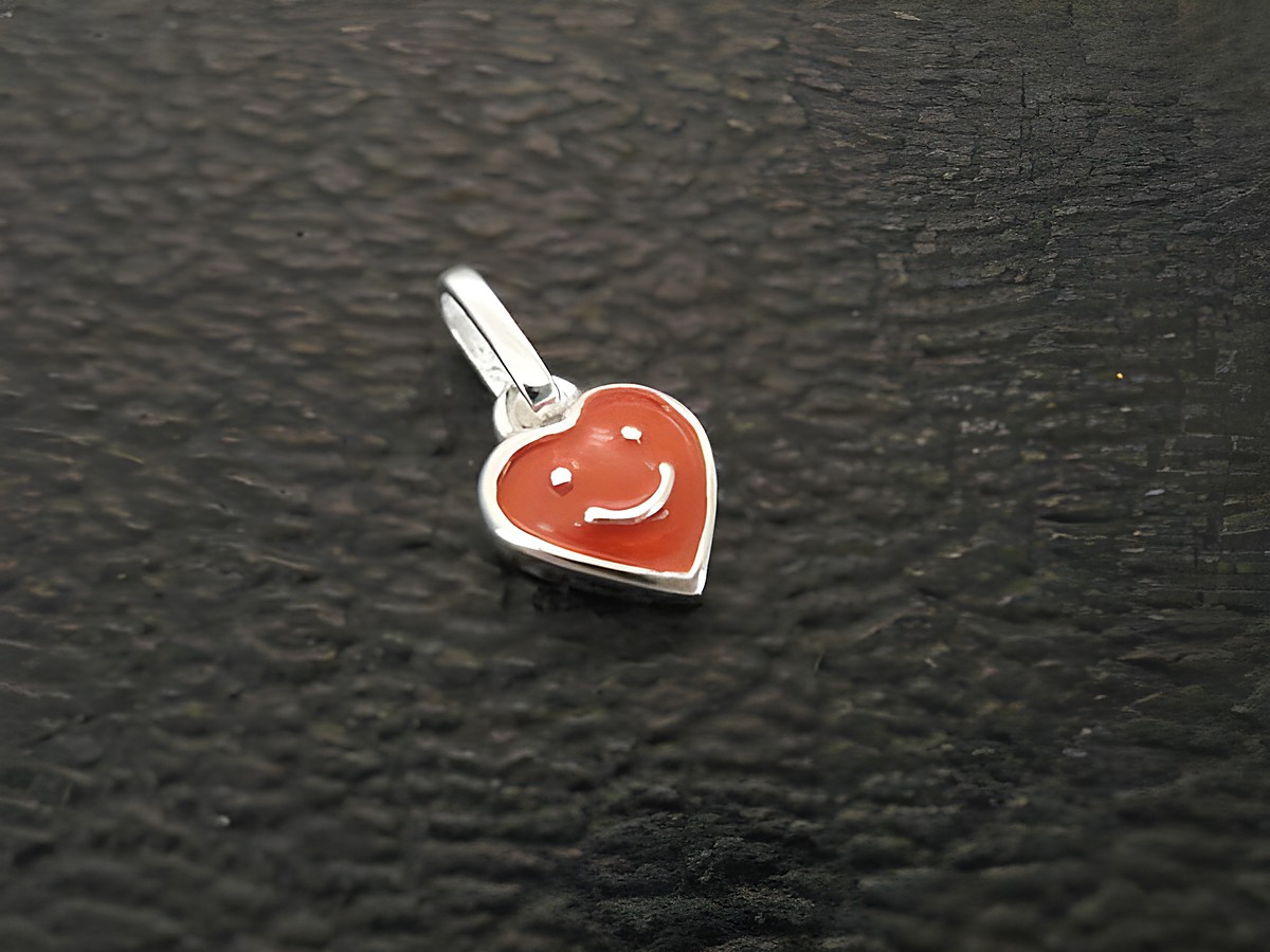 Silber Anhänger Herz süß poliert Emaille rot Hersteller Juwelier Harnisch für Kinder. Der Anhänger zeigt ein rotes Herz mit einem freundlichen Gesichtsausdruck.